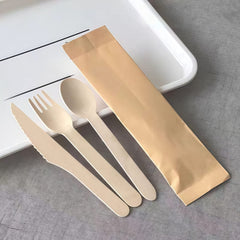 Disposable wooden cutlery set with knife, fork and spoon in kraft paper sleeve, for kids party table settings.