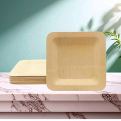 Disposable square bamboo plates for kids party table settings, pack shown stacked on marble surface.