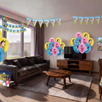 Living room decorated for a Bluey themed kids birthday party with character printed balloons, triangle bunting, happy birthday banner, backdrop and table cover from a OneStopBox party decorations kit.