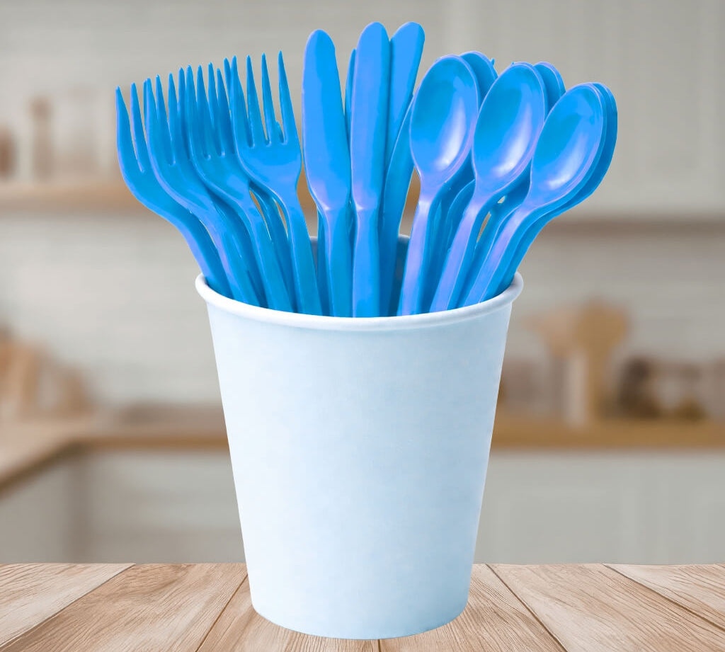 Blue reusable plastic cutlery set with forks, knives and spoons displayed in a white cup, for kids party table settings.