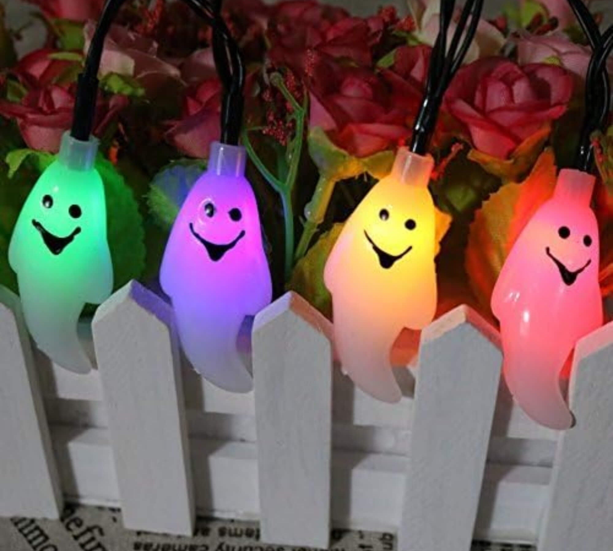 10m LED ghost string lights Halloween decoration with multiple colours and remote, hung on a fence
