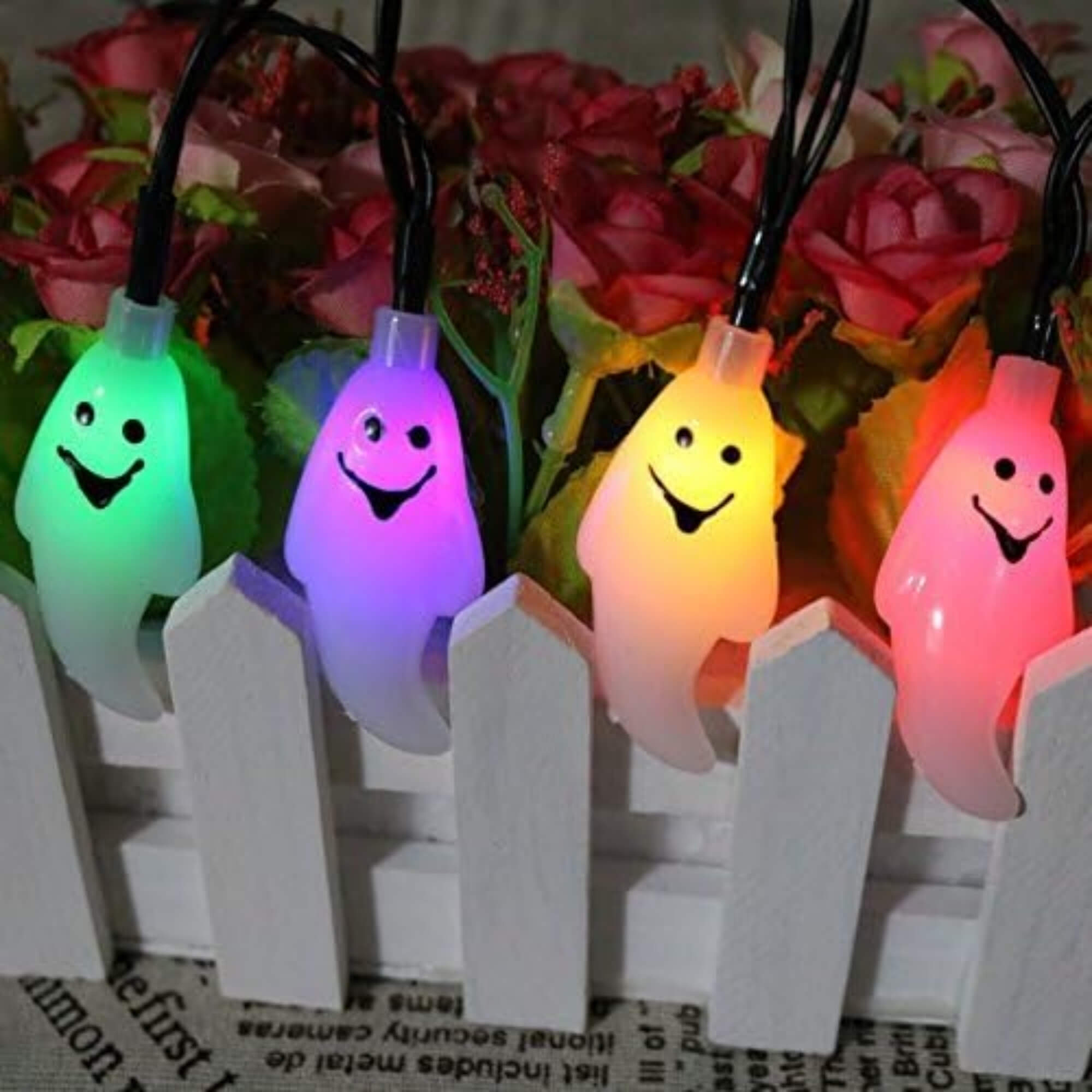 10m LED ghost string lights Halloween decoration with multiple colours and remote, hung on a fence