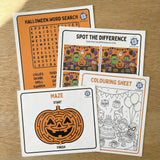 Halloween-themed activity sheets including a word search, spot the difference, and colouring sheet on a wooden surface.