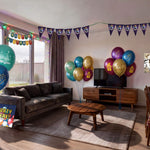 Living room decorated for a Harry Potter themed kids birthday party with wizard printed balloons in gold, teal and burgundy, triangle bunting, happy birthday banner, backdrop and themed table cover from a OneStopBox party decorations kit.