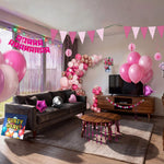 Pink kids birthday party decorations kit Australia, including pink and rose gold balloon garland, balloons, paper fans, honeycomb balls, hanging swirls, dot garland, triangle bunting, fringe curtain, floral wall decorations and table cover.