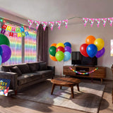 Unicorn rainbow kids birthday party decorations set up in living room, with balloons, banner, fringe curtain and tablecloth, Australia